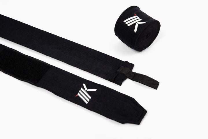 Black pair of 180-inch premium boxing hand wraps by MK1 highlighting their loop thumb closure and secure strap.